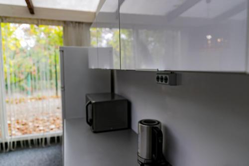 a kitchen with a tv on a counter with a window at Motel1- A megfizethető luxus! in Dunaújváros