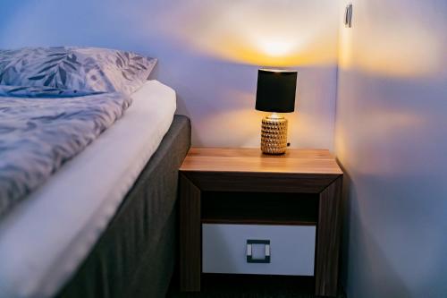 a bed with a nightstand with a lamp on it at Motel1- A megfizethető luxus! in Dunaújváros