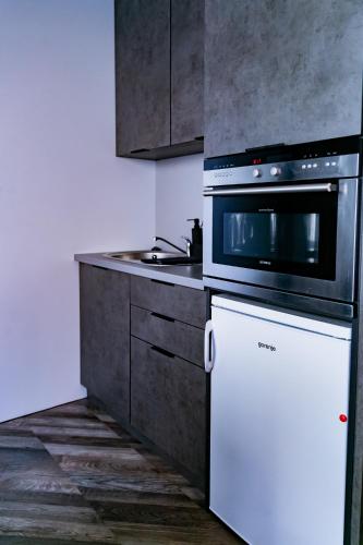 a kitchen with a stove and a white refrigerator at Motel1- A megfizethető luxus! in Dunaújváros