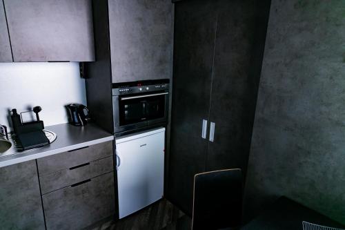 a small kitchen with a stove and a microwave at Motel1- A megfizethető luxus! in Dunaújváros