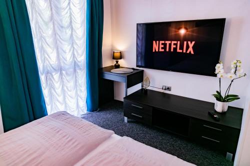 a bedroom with a bed and a flat screen tv at Motel1- A megfizethető luxus! in Dunaújváros