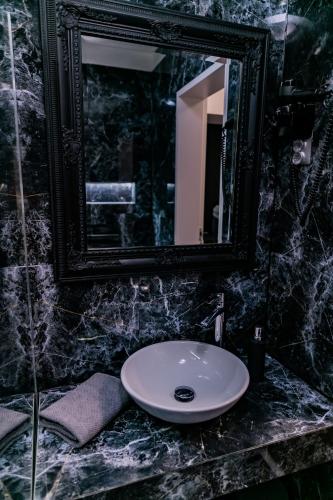 a bathroom with a white sink and a mirror at Motel1- A megfizethető luxus! in Dunaújváros