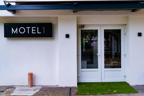 a sign on the side of a building with a door at Motel1- A megfizethető luxus! in Dunaújváros