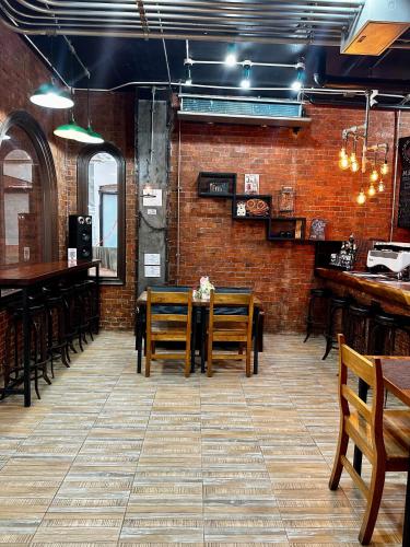 een eetkamer met een tafel en stoelen en een bakstenen muur bij ZEN Hotel Patong Beach -ex- miami Production in Patong Beach