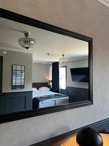 a large mirror in a hotel room with a bed and a bed sqor at Central Hotellet Tierp in Tierp