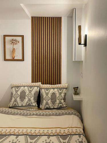 Cette chambre comprend un lit avec deux oreillers et une fenêtre. dans l'établissement Chic studio Marais Paris centre, à Paris