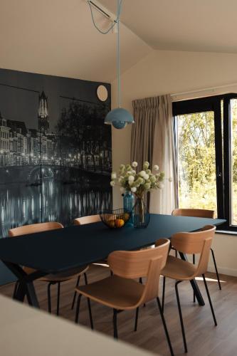 a dining room with a blue table and chairs at Waterlinie Lodges in Utrecht