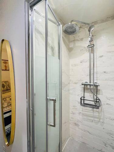 une douche avec une porte vitrée dans une salle de bain dans l'établissement Chic studio Marais Paris centre, à Paris