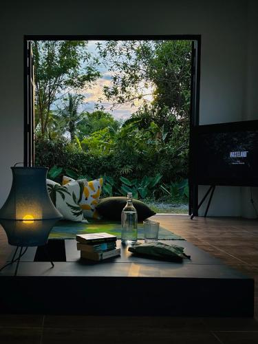 a room with a table with a bottle and a window at Waste Land Homestay & Resort Chiangmai in San Pa Tong
