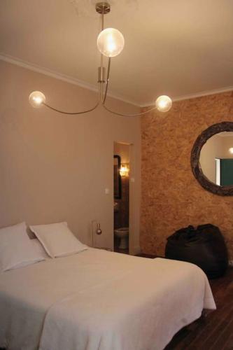 une chambre avec un lit blanc et un miroir dans l'établissement Spacieux appartement 4 couchages, terrasse privée, à Narbonne