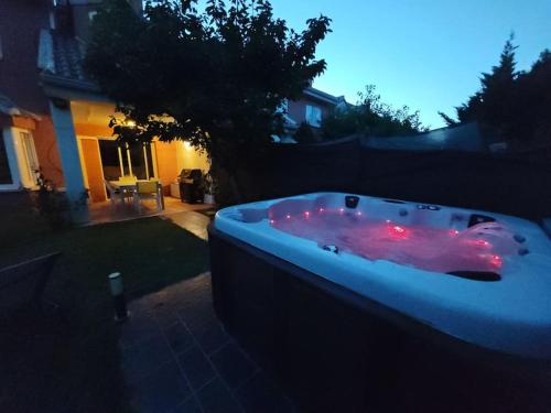 a hot tub with red lights in a yard at Marel Valladolid in Aldeamayor de San Martín
