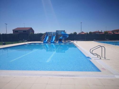 an empty swimming pool with blue slides in it at Marel Valladolid in Aldeamayor de San Martín