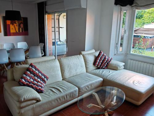 a living room with a white couch and a glass table at Marel Valladolid in Aldeamayor de San Martín