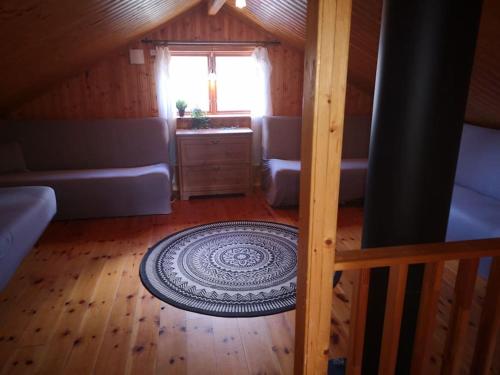 a attic room with a rug on a wooden floor at Sjö-Stuga 6 B in Landvetter