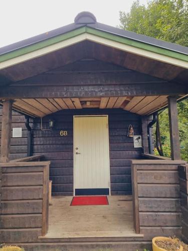a small house with a white door and a porch at Sjö-Stuga 6 B in Landvetter