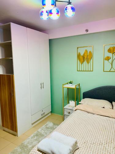 a bedroom with green and white walls and a bed at DM Condo Unit Rental in Dumaguete