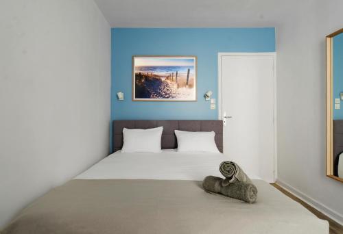 une chambre avec un grand lit aux murs bleus dans l'établissement Le Petit Pasteur - Appartement design avec Sauna, à Vichy