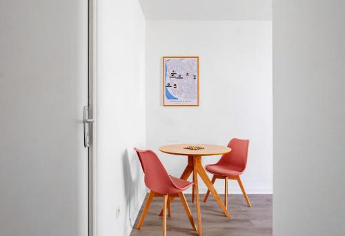une table et quatre chaises dans une pièce dans l'établissement Le Petit Pasteur - Appartement design avec Sauna, à Vichy