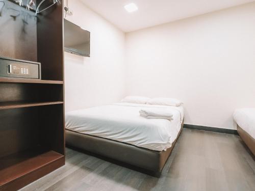 a small room with a bed and a tv at A Hotel Desker in Singapore