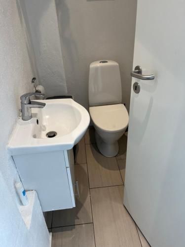 a bathroom with a white sink and a toilet at Billund mini hostel room 10 - Tæt på LEGOLAND og LEGO House in Billund