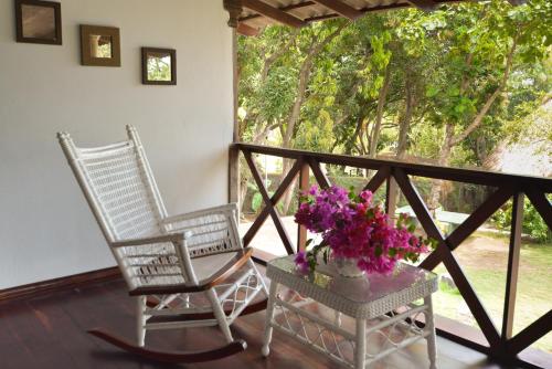 two chairs sitting on a porch with flowers in a vase at Laguna Beach Club in La Laguna