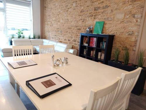 a dining room with a white table and chairs at Les Meublés des Pierres Dorées - Gite de charme pour groupe in Theizé