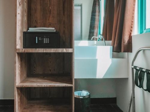 a kitchen with a microwave in a wooden cabinet next to a sink at A Hotel Desker in Singapore
