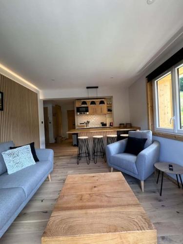 un salon avec deux canapés bleus et une table dans l'établissement Picot Apartment, à Morzine