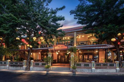 a large building with trees in front of it at The Signature Hoi An in Hoi An