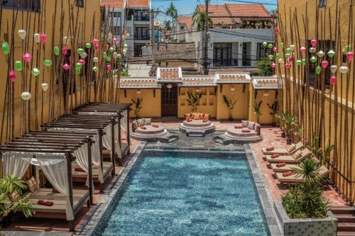 an outdoor pool with chaise lounges and a resort at The Signature Hoi An in Hoi An