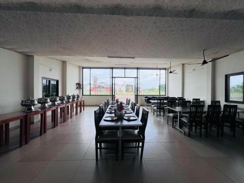 a dining room with tables and chairs and large windows at Unity Sunrise Resort Best Hotel Near Statue of Unity in Kevadia