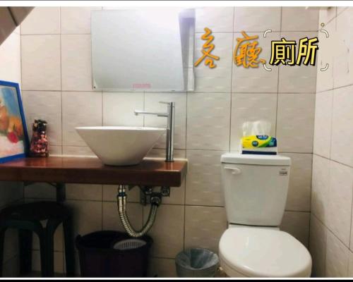 a bathroom with a sink and a toilet at Mamamia Homestay in Hengchun