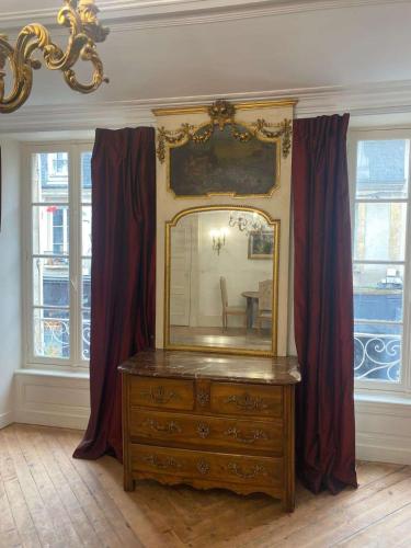 une pièce avec une commode avec un miroir dessus dans l'établissement Le royal, F2 en centre-ville, à Bayeux