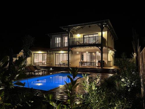 une maison avec piscine la nuit dans l'établissement Spacieuse Villa sous les pins & piscine, à Andernos-les-Bains