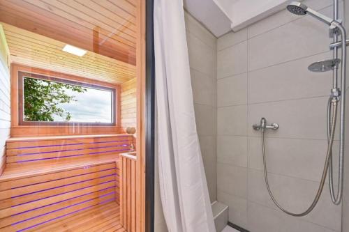 a bathroom with a shower and a window at Vila Ivka Holiday Resort in Donja Poljana