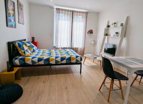 une chambre avec un lit et un bureau avec un ordinateur dans l'établissement STUDIO HELSINKI - Style et Modernité, à Charleville-Mézières