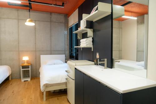 a bathroom with a sink and two beds in a room at Local Stitch Creator Town Seogyo in Seoul