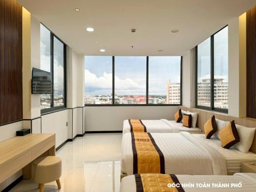 two beds in a room with large windows at KHÁCH SẠN 101 CẦN THƠ in Can Tho