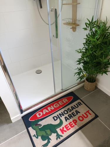 a bathroom with a sign that reads danger dinosaur entrance and keep out at OUT a TIME in Angoville-sur-Ay