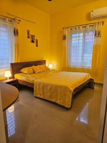 1 dormitorio con 1 cama con paredes y ventanas de color amarillo en 2 BHK APT in RustamBagh - Indranagar, en Bangalore