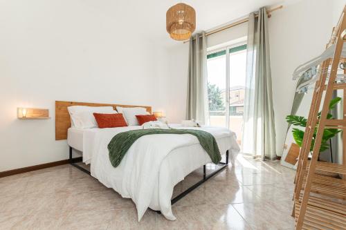 a bedroom with a bed with white sheets and red pillows at Méditerranée - 200m dal Mare, Parcheggio Privato, Idromassaggio in Imperia
