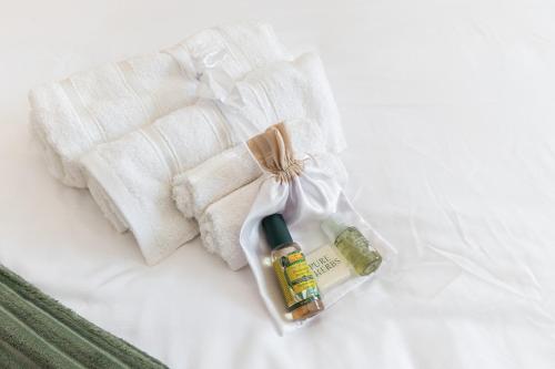 a pile of towels and a bottle of oils on a bed at Méditerranée - 200m dal Mare, Parcheggio Privato, Idromassaggio in Imperia