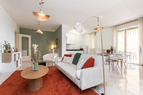 a living room with a white couch and a table at Méditerranée - 200m dal Mare, Parcheggio Privato, Idromassaggio in Imperia