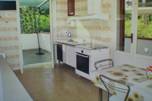 a kitchen with a stove and a table in it at LA GRANDE Musa in Fontane Bianche