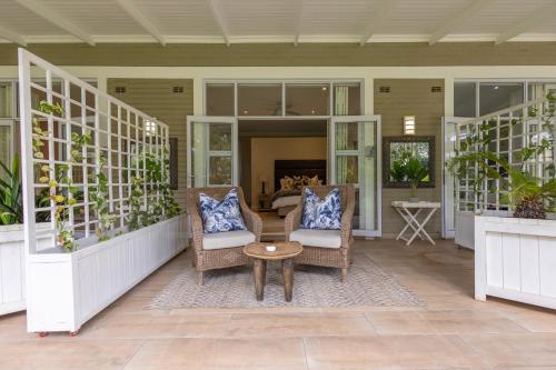a porch with wicker chairs and a table at Ridgeway Place in Harare