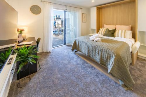 クライストチャーチにあるLuxury Studio With Balcony - Close to Supermarketの大きなベッドとバルコニーのある寝室