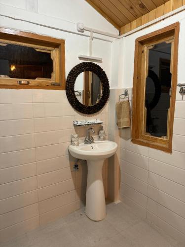 a bathroom with a sink and a mirror at Avasaa Café and Stay in Jibhi