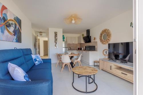 un salon avec un canapé bleu et une table dans l'établissement Inka - appt vue mer et montagne, à Lumio