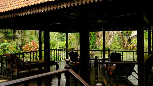 a porch of a house with chairs and an umbrella at Deluxe bedroom at Rumah Sentosa in Kampong Sum Sum