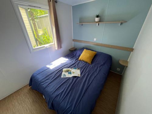 a small bedroom with a bed with a book on it at Camping de Châlons-en-Champagne in Châlons-en-Champagne